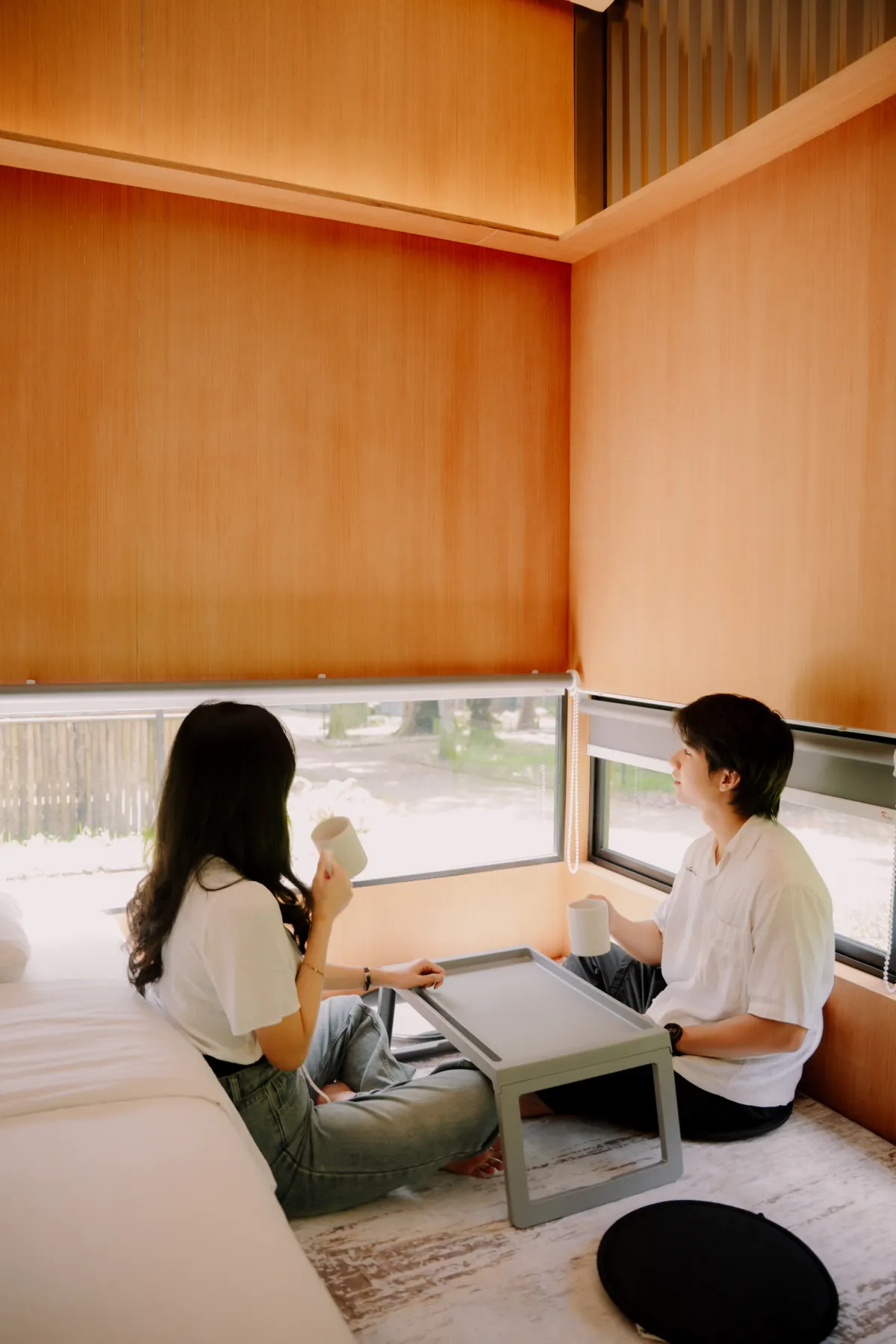 Couple relaxing with morning drinks inside a private Jiwanta cabin